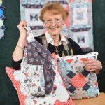 Jennie Rayment holding up quilt